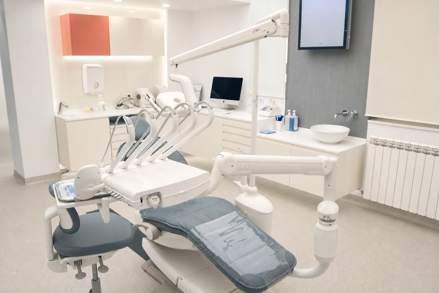 An operatory at the clinic, with the chair, overhead light and monitor.